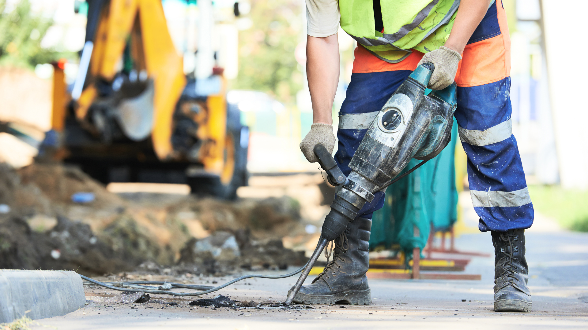 a construction worker drilling into a road during ongoing roadworks